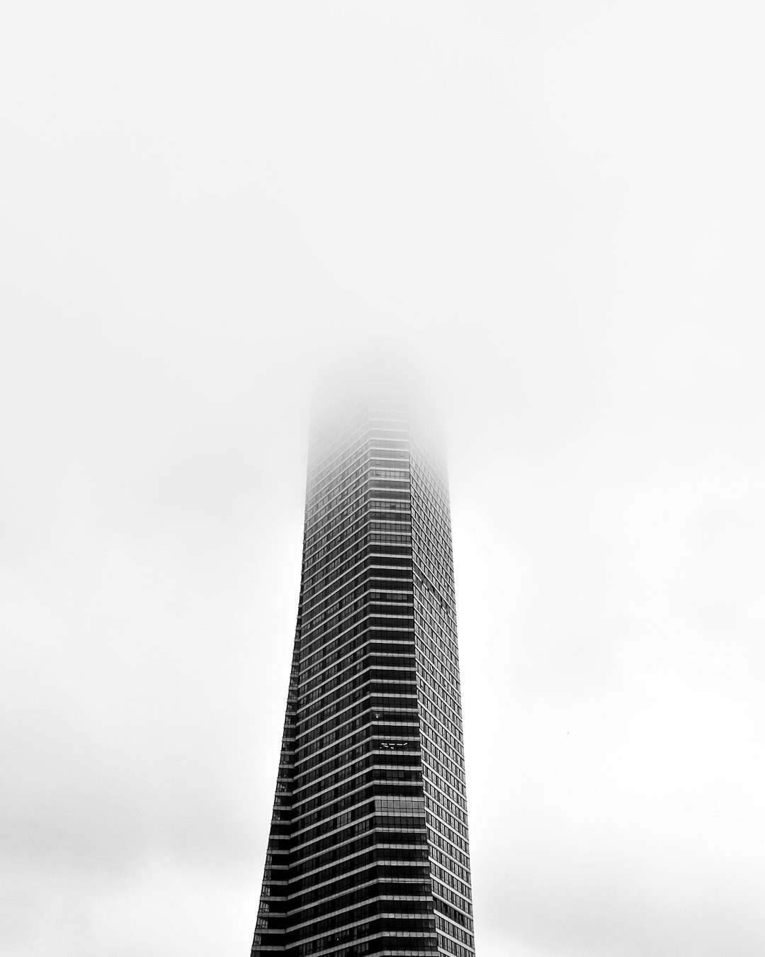 futuristic black skyscraper rising through the clouds and the fog. 